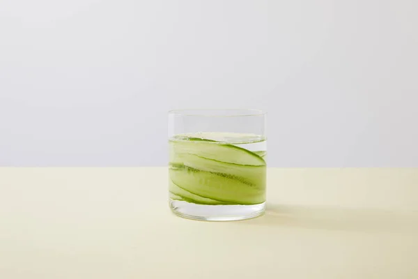 Glass Fresh Water Sliced Cucumbers Yellow Surface Isolated Grey — Stock Photo, Image