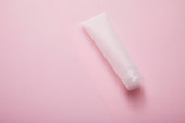 Magas szög kilátás műanyag kozmetikai krém cső rózsaszín háttér