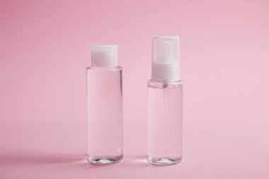 Sanitizer spray and lotion bottle on pink background clipart