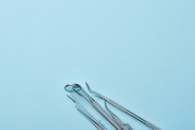 Mavi arkaplanda metal profesyonel diş aletlerinin yüksek açılı görünümü