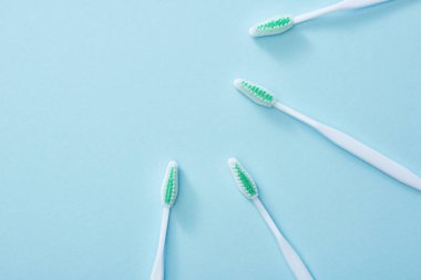 Mavi arkaplanda beyaz diş fırçalarının üst görünümü