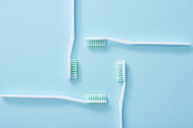 Flat lay with toothbrushes set on blue background clipart