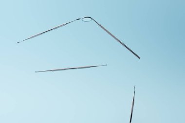 Mavi arkaplanda izole edilmiş metal diş aletleri