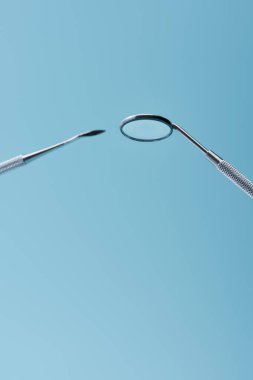 Mavi arkaplanda metal diş inceleme araçları izole edildi