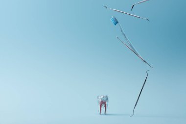 Diş paslanmaz ekipman, diş fırçası ve mavi arka planda yapay plastik diş.