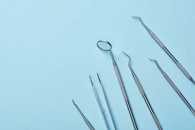 Mavi arkaplanda metal diş aletlerinin yüksek açılı görüntüsü
