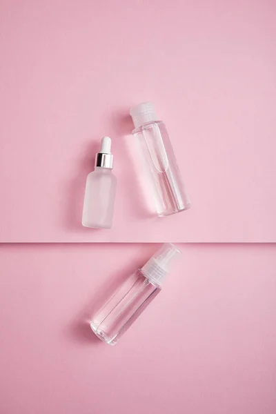 粉红纸背透明化妆品瓶 喷雾及血清瓶的顶视图 — 图库照片