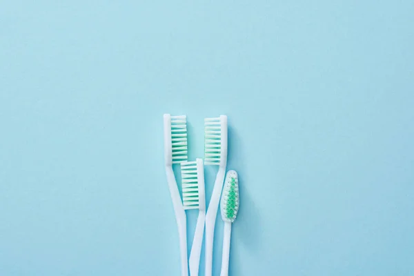 Draufsicht Auf Weiße Zahnbürsten Mit Grünen Borsten Auf Blauem Hintergrund — Stockfoto