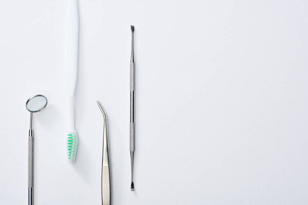 Top view of dental instruments and toothbrush on grey background