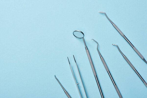 High angle view of metal dental equipment on blue background