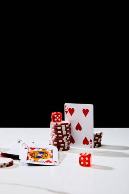 Kumarhane jetonları, zarlar ve oyun kartları beyaz yüzey üzerinde izole edilmiş siyah