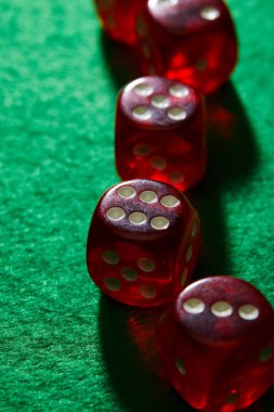 Selective focus of red dice on green background clipart