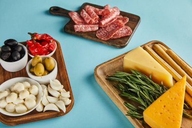 Yüksek açılı salam dilimleri ve panolarda bulunan antipasto malzemeleri.