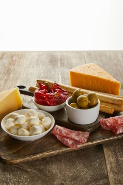 Tahtadaki ahşap yüzeydeki antipasto malzemelerinin yüksek açılı görüntüsü beyaz üzerinde izole edilmiş.