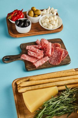 Mavi arka plandaki panolarda bulunan antipasto malzemelerinin yüksek açılı görünümü