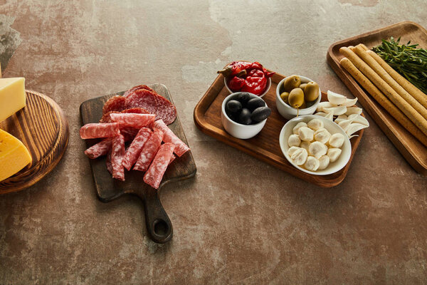 High angle view of antipasto ingredients on boards on brown