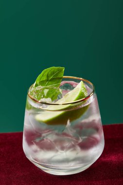 Soğuk mojito manzarasını kapatın. Camda nane şekeri ve yeşil üzerinde izole edilmiş altın kenarlı. 