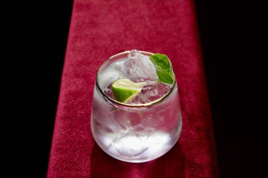 Taze mojito, nane ve kireç dilimleri siyah üzerine izole edilmiş yüksek açılı cam manzaralı. 