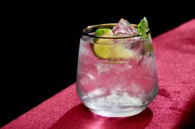 Limonlu mojito, naneli ve buzlu. Siyah bardakta izole edilmiş. 