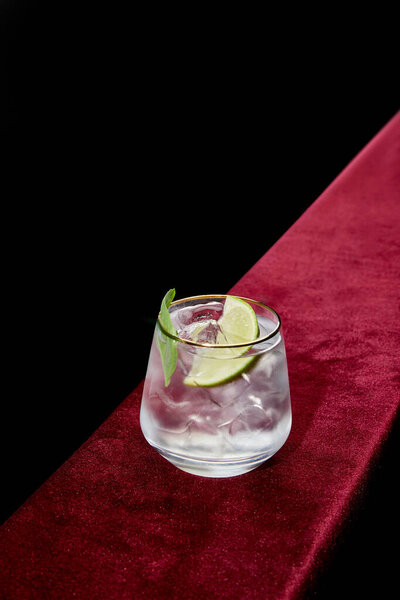 High angle view of  old fashioned glass with refreshing mojito, mint and lime slice isolated on black