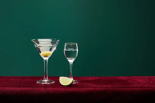 玻璃杯和鸡尾酒杯 牙签上有苦艾酒 柠檬片和整个橄榄 与绿色隔绝 — 图库照片