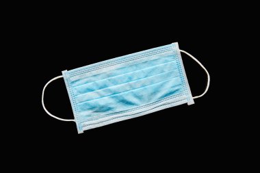 Siyah üzerine izole edilmiş mavi tıbbi maskenin üst görüntüsü 