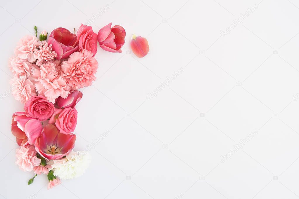 top view of pink spring flowers on white background with copy space