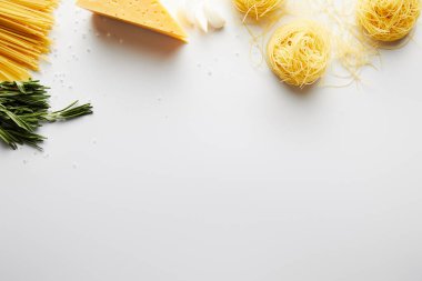 Beyaz arka planda biberiye, sarımsak, peynir ve makarna manzarası 