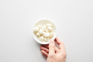 Beyaz arka planda mozzarellalı kaseli erkek eli. 