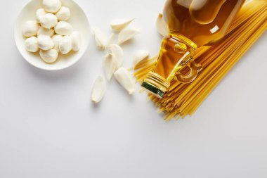 Sarımsak, mozarella, spagetti ve beyaz arka planda bir şişe zeytinyağı. 