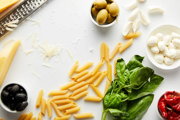 Ovanifrån Rivjärn Pasta Basilika Blad Och Ingredienser Vit Bakgrund — Stockfoto