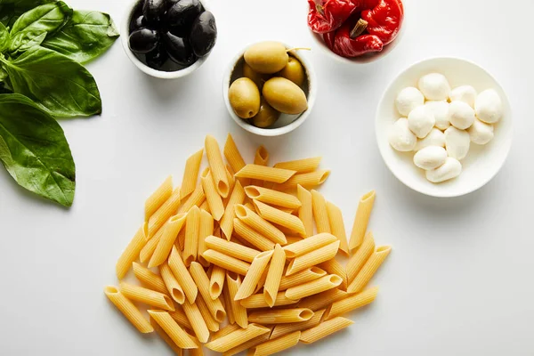 Bovenaanzicht Van Pasta Buurt Van Basilicum Bladeren Kommen Met Ingrediënten — Stockfoto