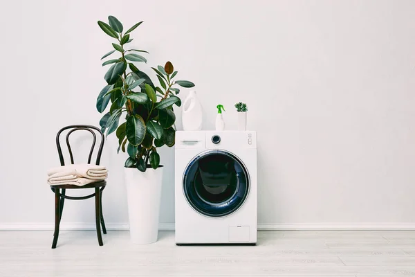 Plantas Verdes Cerca Lavadora Con Botellas Cerca Silla Con Toallas — Foto de Stock