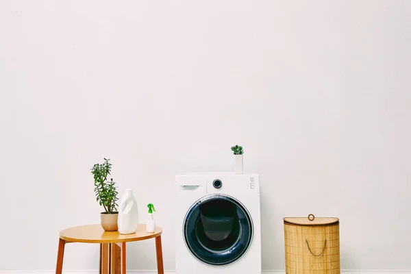 나무로 테이블 화장실에 세탁물 바구니와 현대식 세탁기 — 스톡 사진
