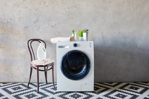 Wasmiddel Spuitflessen Buurt Van Wasmachine Planten Handdoeken Stoel Siertapijt Badkamer — Stockfoto