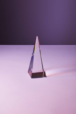 crystal transparent pyramid with light reflection on violet and purple background clipart