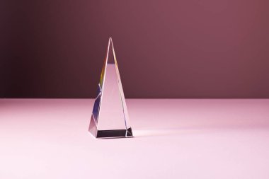 crystal transparent pyramid with light reflection on pink background clipart