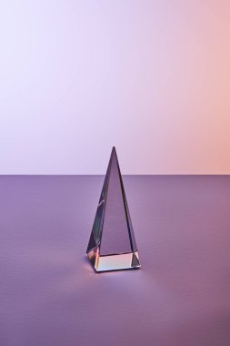 crystal transparent pyramid with light reflection on violet and purple background clipart