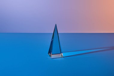 crystal transparent pyramid with light reflection on blue background clipart