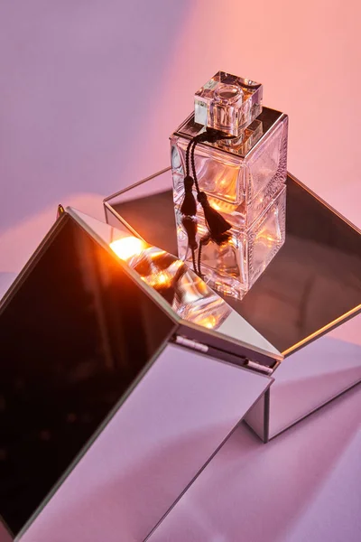 Parfüm Şişesi Ayna Küpleri Üzerinde Pembe Arka Planda Işık Ile — Stok fotoğraf
