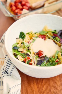 Yüksek açılı makarna salatası ve ahşap arka planda peçetenin yanında mayonez.