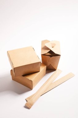 Çin yemeği ve yemek çubuklarıyla dolu kutular beyaz paketler. 