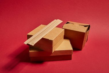 Yemek çubukları paket kağıdında, paket kutusunun yanında. Kırmızı üzerinde Çin yemeği var.