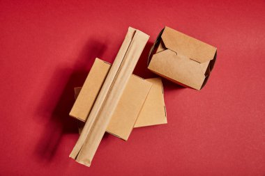 Yemek çubuklarının kağıt ambalajında üst görüntüsü paket paketlerinin yanında kırmızı üzerinde geleneksel Çin yemekleri var.