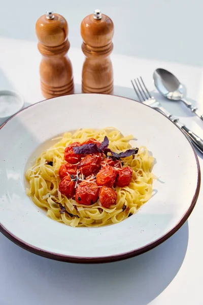 Pyszne Makarony Pomidorami Serwowane Sztućcami Solą Pieprzem Młyny Białym Stole — Zdjęcie stockowe