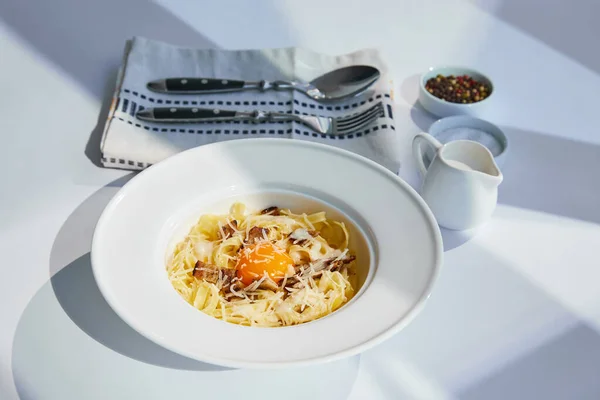 Delicious Pasta Carbonara Served Cutlery Cream Seasoning White Table Sunlight — Stock Photo, Image