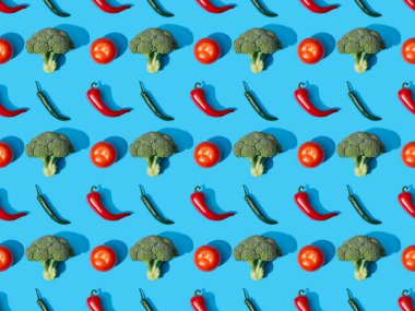 top view of fresh green broccoli, chili peppers and tomatoes on blue background, seamless pattern clipart