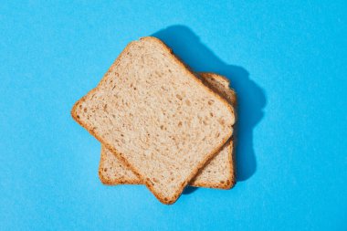 top view of fresh toast bread on blue colorful background clipart