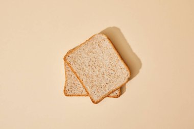 top view of fresh toast bread on beige background clipart