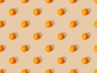 Bej arkaplanda olgun portakalların üst görünümü, pürüzsüz desen